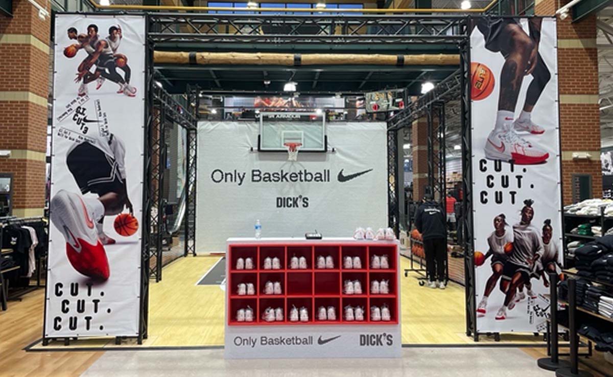 A Nike Basketball brand activation inside a Dick's retail store with a red shoe rack and miniature basketball court